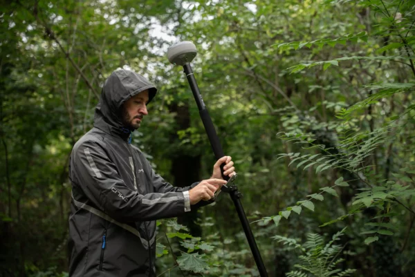 Un technicien utilise sous la pluie un Reach RS4 en utilisant la centrale inertielle