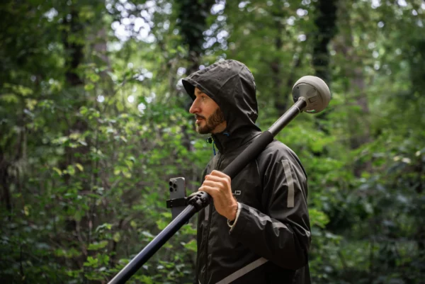 Un ingénieur sous la puie dans une foret utilise le Reach RS4